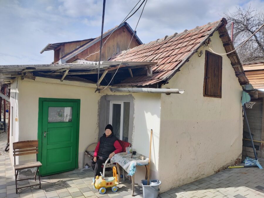 Olga, vecina lui Julius, în fața camerei construită de el